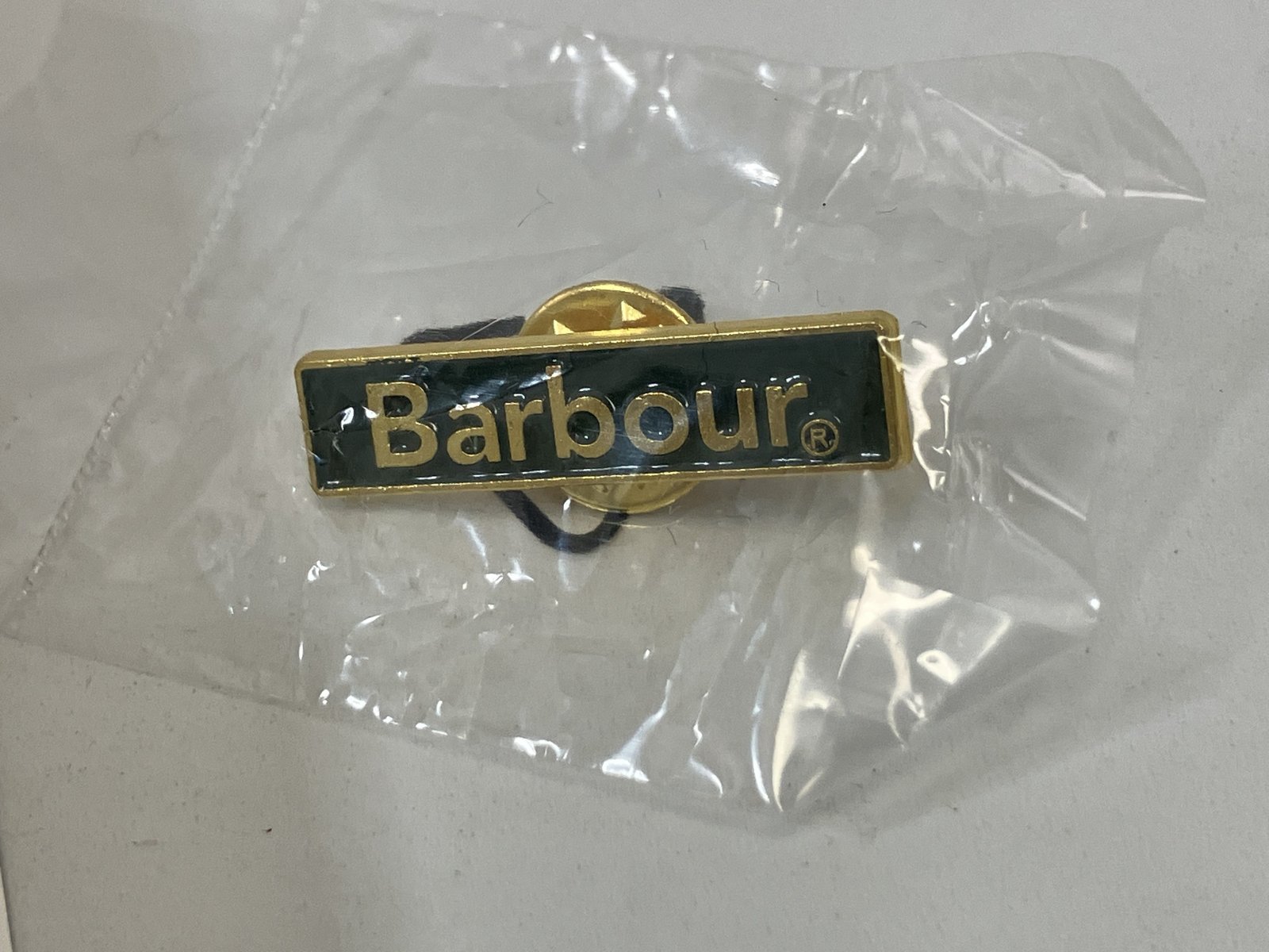 買ったときに店員さんが付けてくれたピンバッジ(袋に入ったまま)